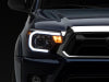 Raxiom 12-15 Toyota Tacoma Axial Projector Headlights w/ SEQL LED Bar- Black Housing (Clear Lens)
